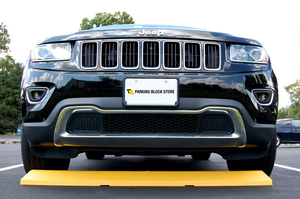Image of yellow parking block in front of black car